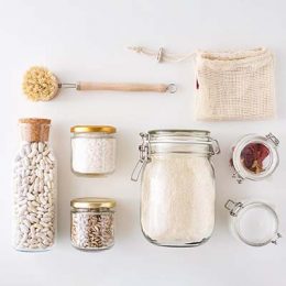 Glass jars with food ingredients on white background, top view. Zero waste concept. Kitchen background with eco friendly utensils